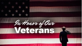 In Honor of Our Veterans. A U.S. soldier is saluting against an American flag background.